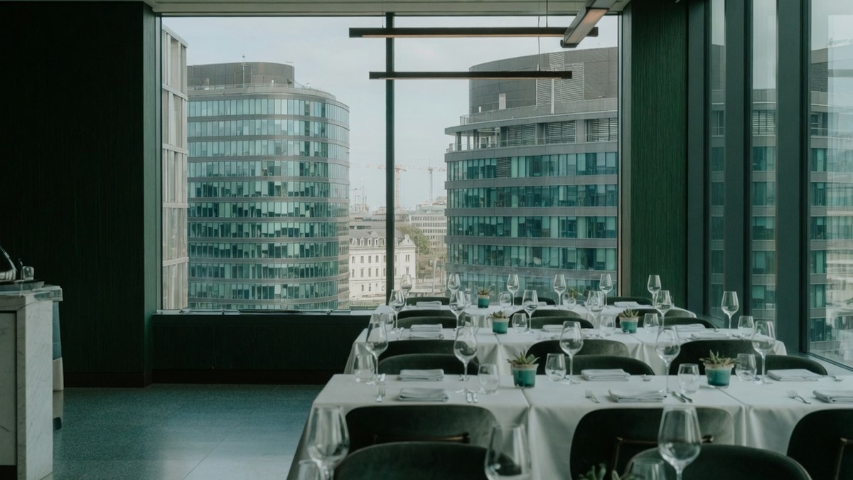 Salle de restaurant lumineuse avec grandes baies vitrées donnant sur les tours de bureaux du plateau du Kirchberg à Luxembourg